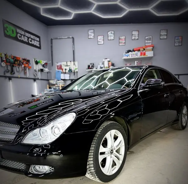 Чёрный Mercedes CLS в боксе под потолочным светом