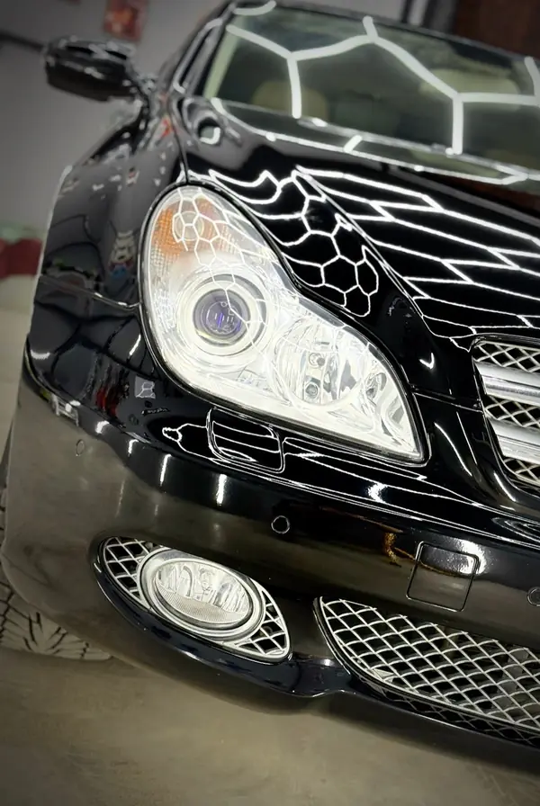 Чёрный Mercedes CLS: фара и решётка бампера с отражением линий света