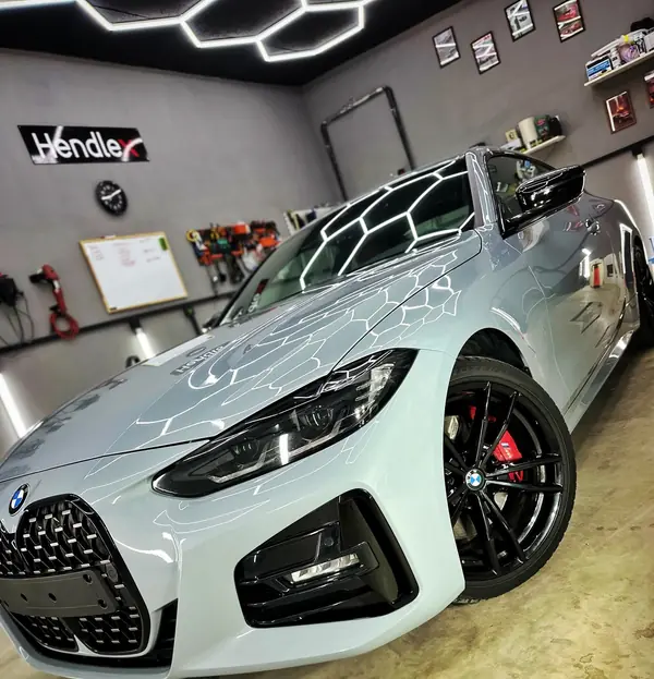 Серо-голубой BMW M440 в боксе под белыми линиями света